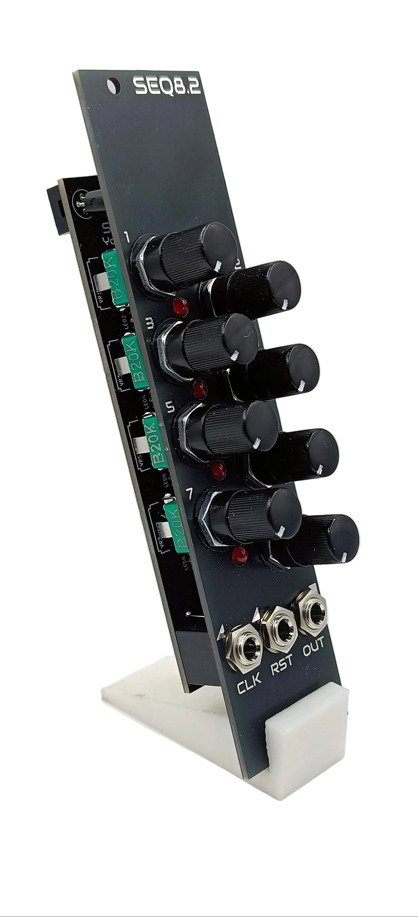 Black electronic module with knobs and connectors on a white background