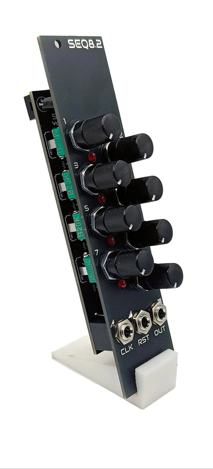 Black electronic module with knobs and connectors on a white background